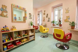 Intérieur d'un salon de coiffure pour enfants avec fauteuils en forme de voiture et décoration murale colorée aux motifs animaux